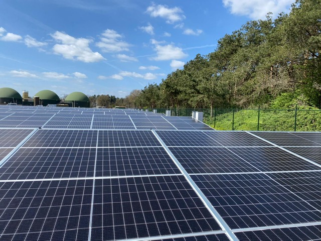 Zonnepanelen van Klimaatpark Lungendonk met de vergistingsinstallatie op de achtergrond