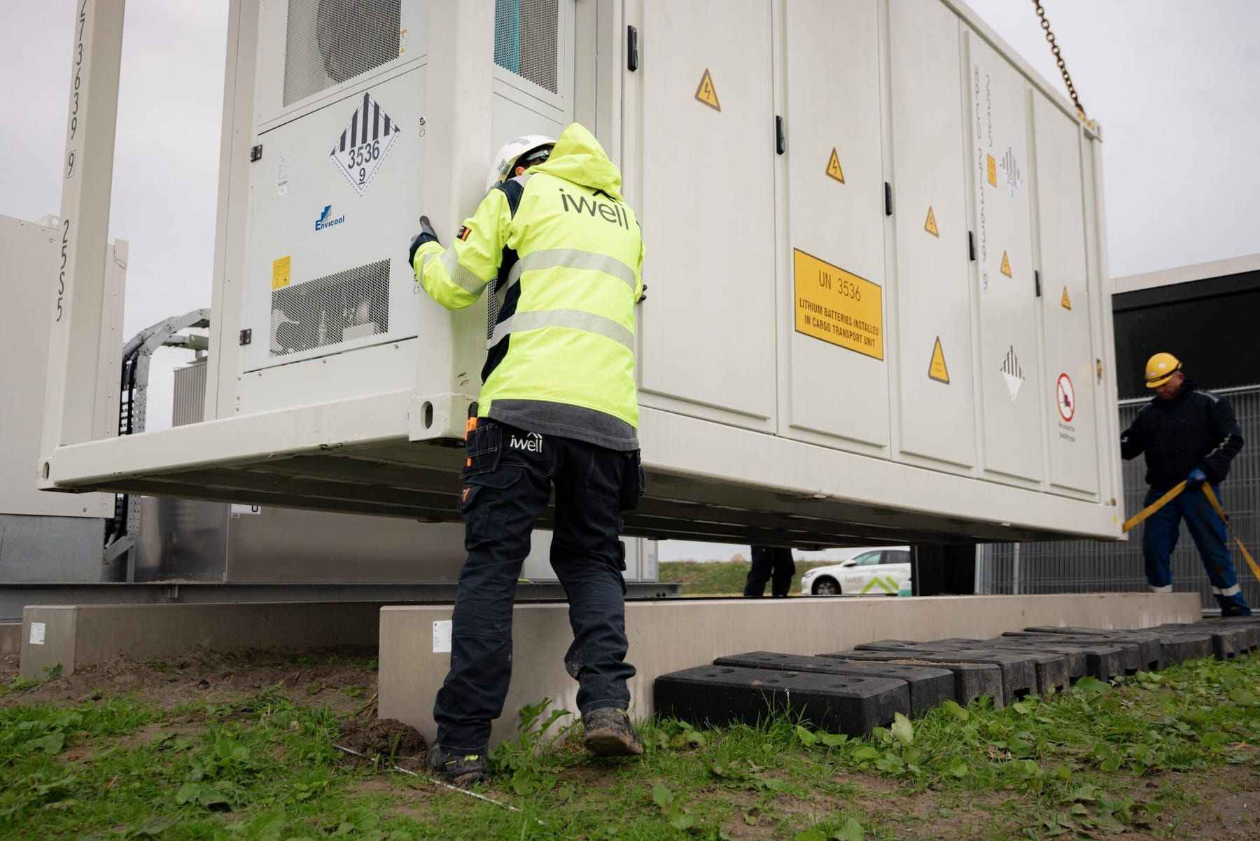 Monteur van iwell werkt aan de geplaatste batterijcontainer